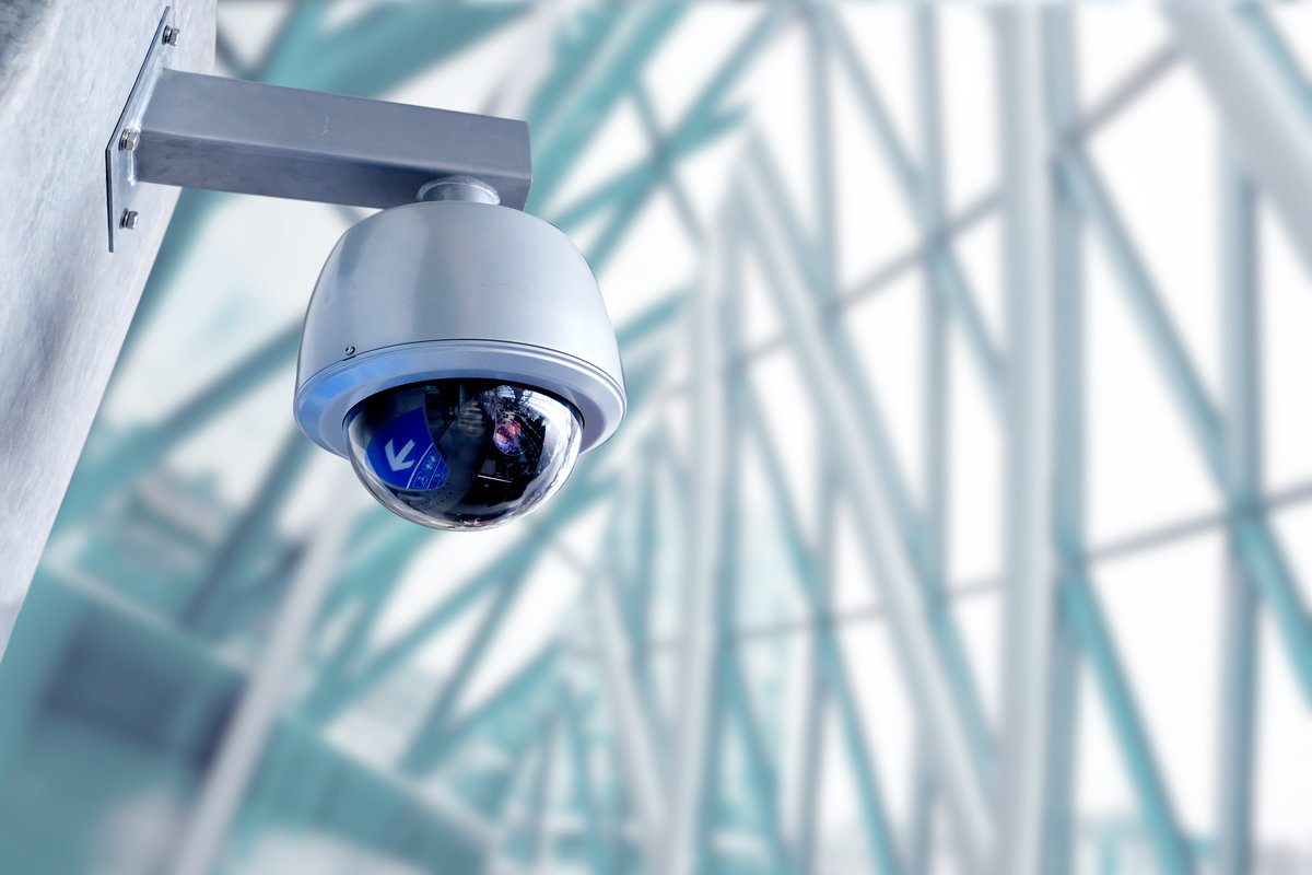 Security camera in a nice glass and steel architectural space. A stock photo. Serving here as a security themed photo.