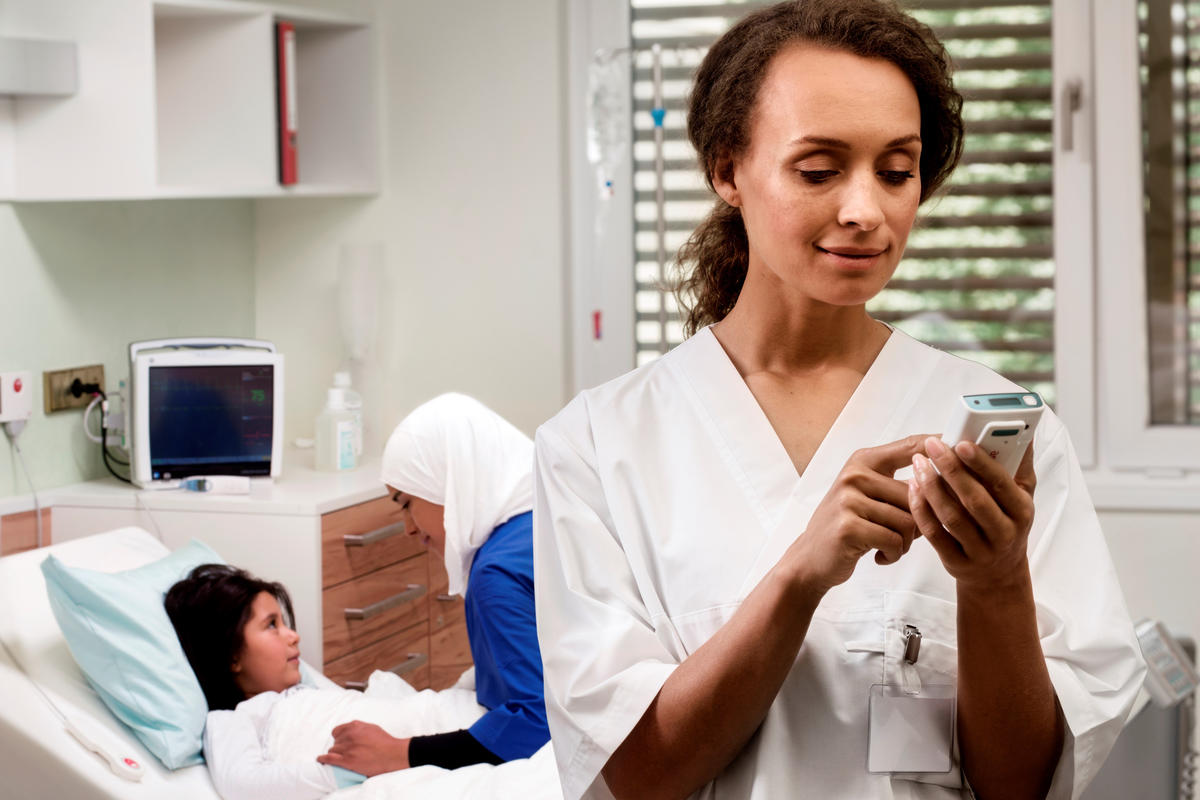 A nurse in a hospital using an Ascom Myco 3 mobile device.